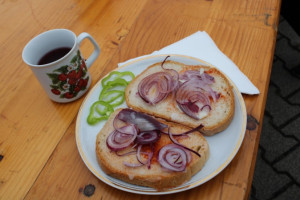 Készül a zsíros kenyér lila hagymával és csípős paprikával
